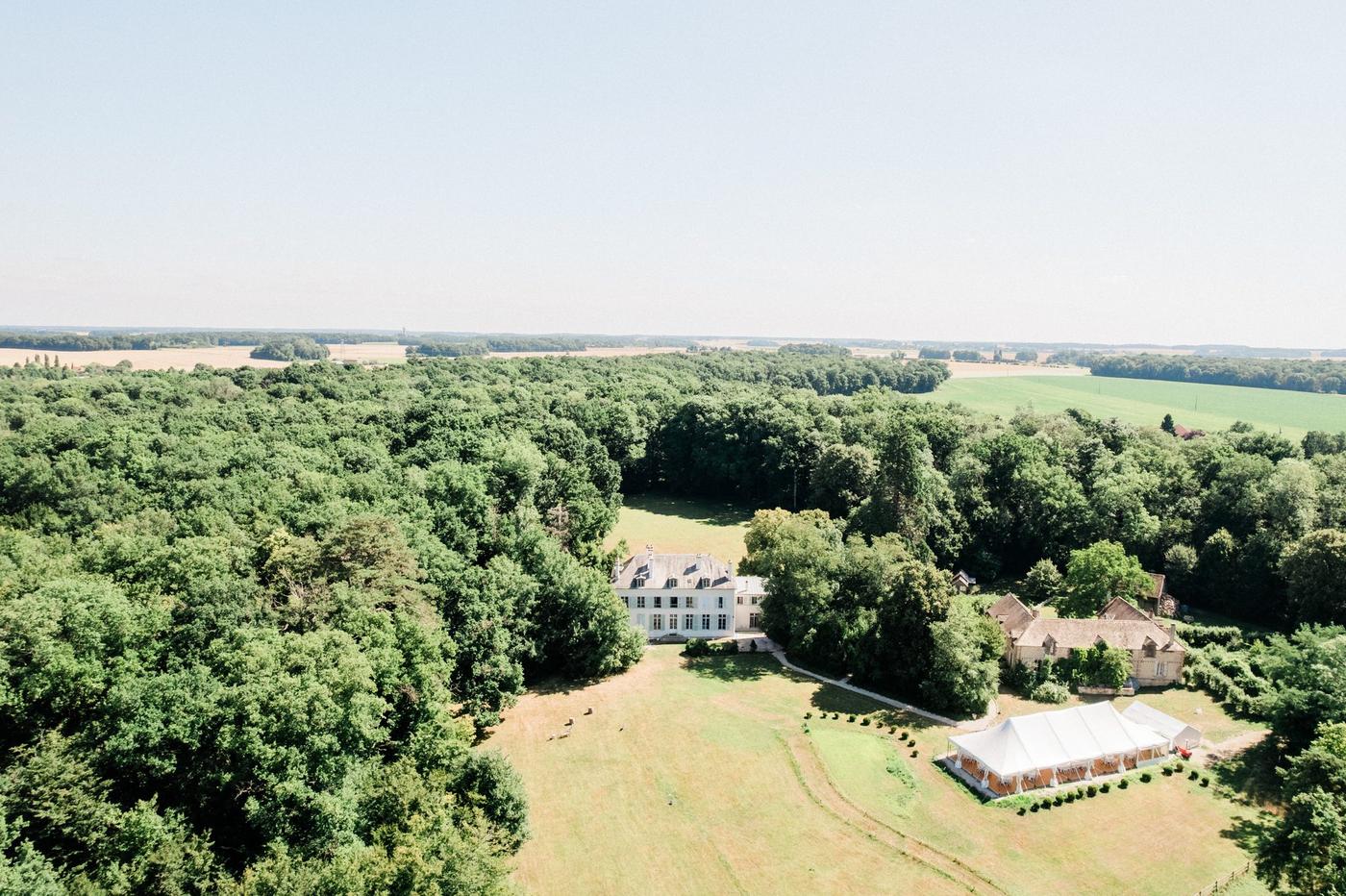 Vue aérienne du domaine de Séréville : le château, le chapiteau bambou et la ferme en lisière de forêt